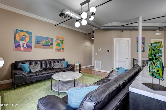 living area with wood finished floors, baseboards, visible vents, and ornamental molding