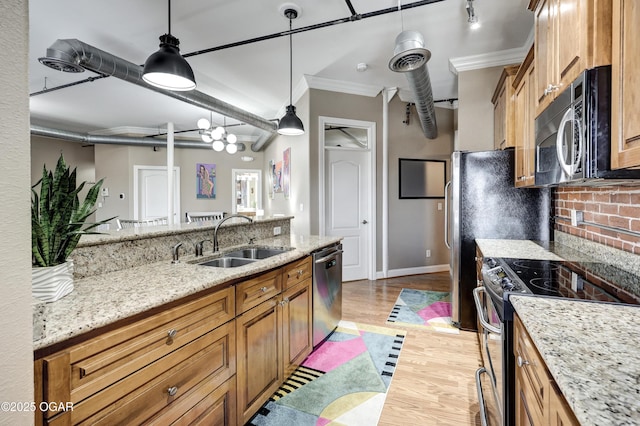 kitchen featuring brown cabinetry, a sink, stainless steel appliances, crown molding, and tasteful backsplash