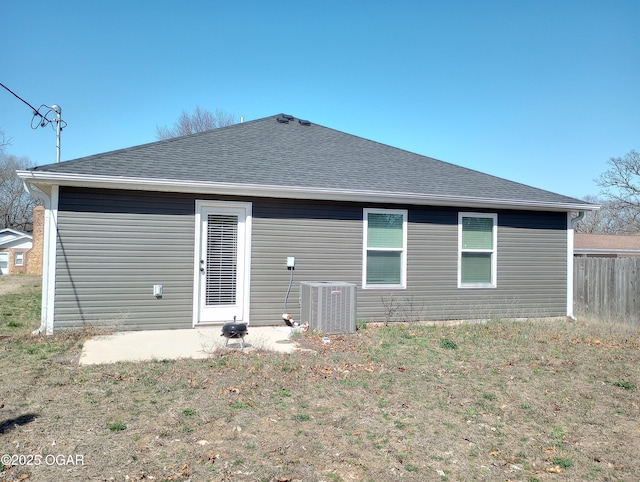 back of property featuring cooling unit, fence, and roof with shingles