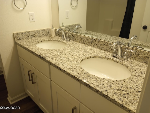 full bathroom with a sink, baseboards, and double vanity