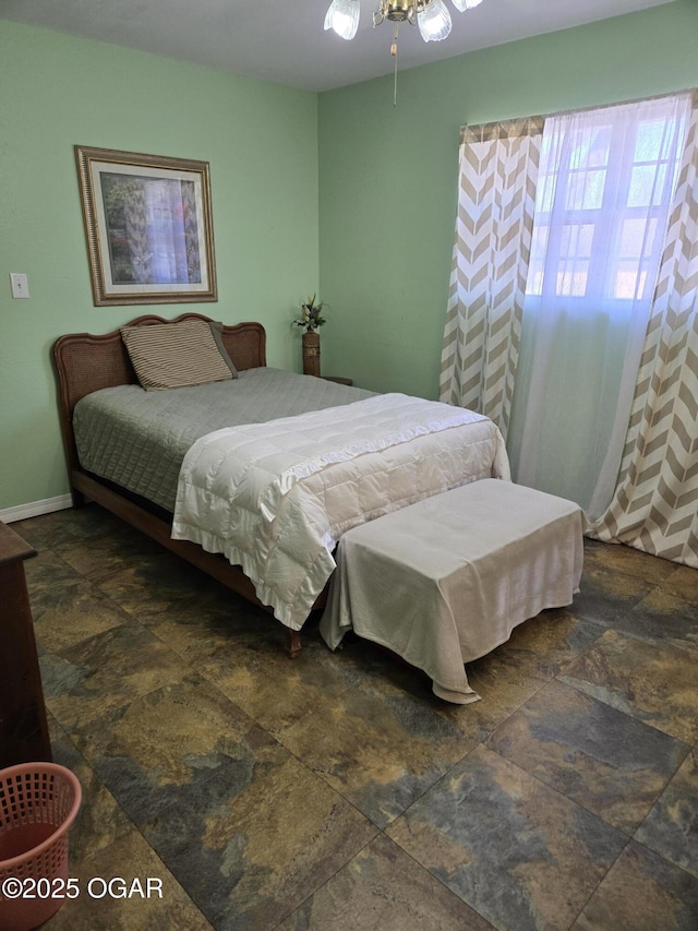 bedroom featuring stone finish flooring and baseboards