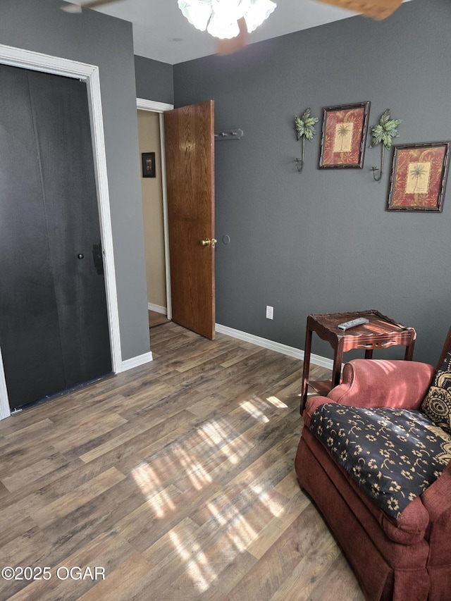 bedroom with wood finished floors, baseboards, and a closet