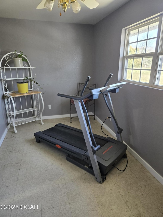 workout area with a ceiling fan and baseboards