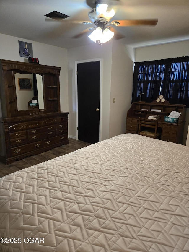 bedroom with visible vents, wood finished floors, and a ceiling fan