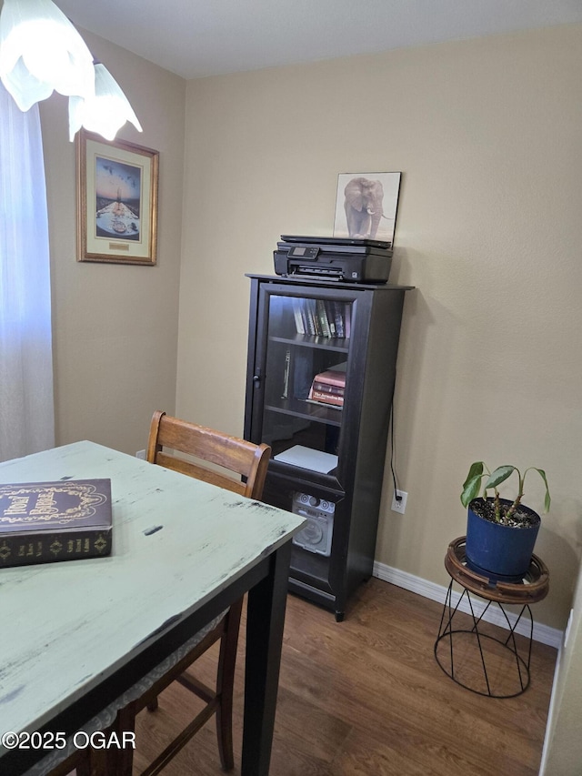 dining space featuring baseboards and wood finished floors