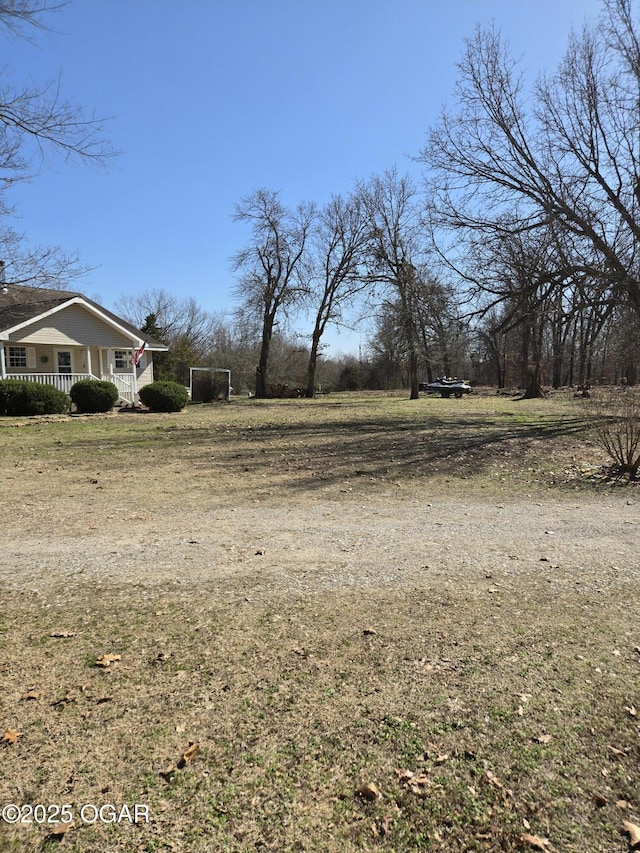 view of yard featuring covered porch and driveway