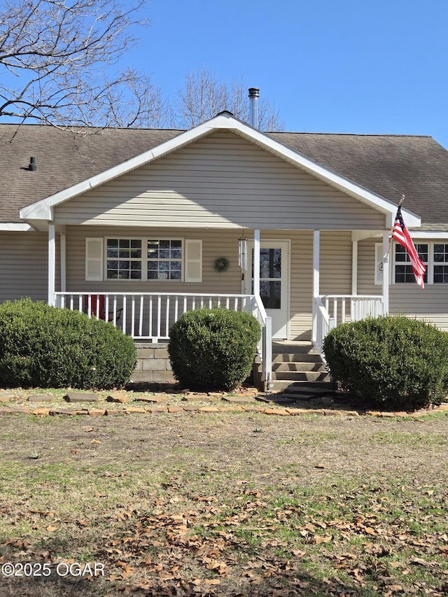 view of front of house featuring roof with shingles and covered porch