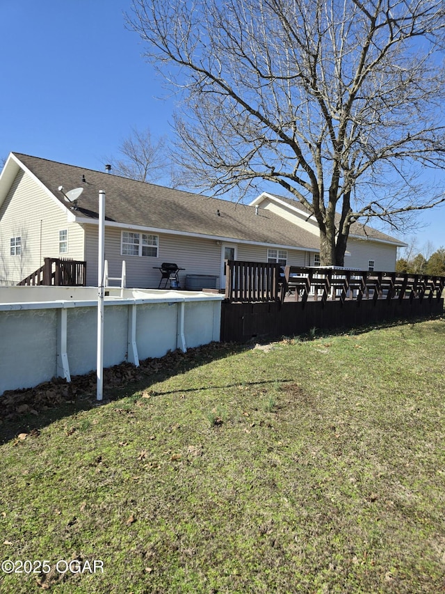 exterior space featuring an outdoor pool and a yard