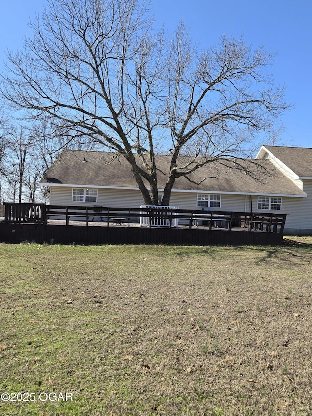 rear view of house with a lawn and a deck