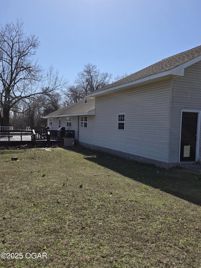 back of house featuring a lawn and a wooden deck