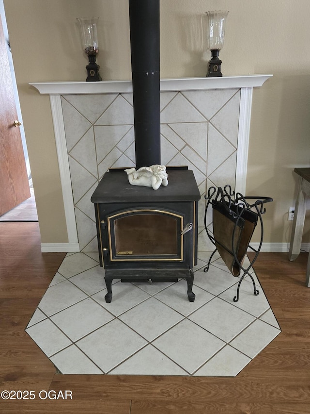 room details with baseboards, wood finished floors, and a wood stove