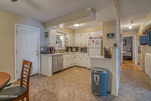 kitchen with white cabinetry, stainless steel dishwasher, black microwave, and light countertops