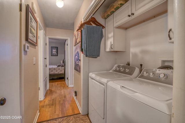 laundry area with separate washer and dryer, cabinet space, and baseboards