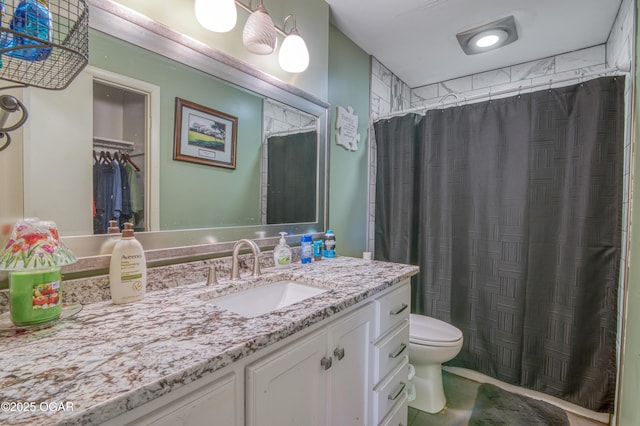 bathroom with toilet, vanity, and a shower with curtain