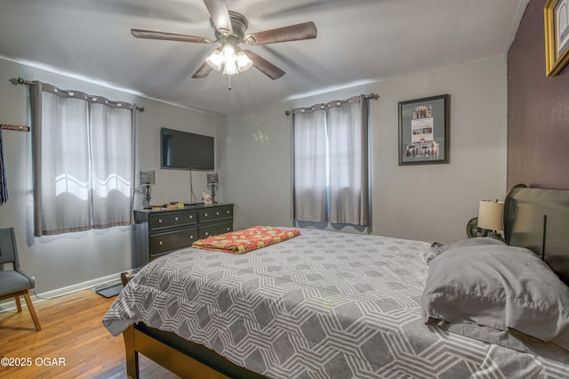 bedroom featuring a ceiling fan, wood finished floors, and baseboards