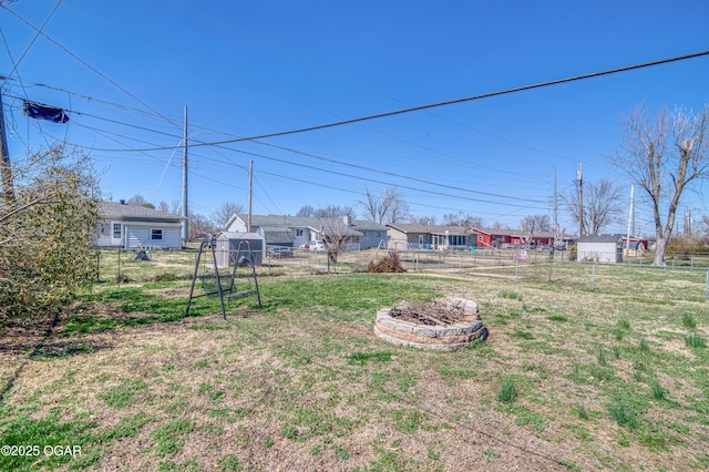 view of yard featuring an outdoor fire pit and fence