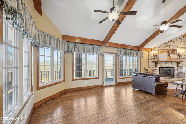 living area with visible vents, a fireplace, a ceiling fan, and wood finished floors