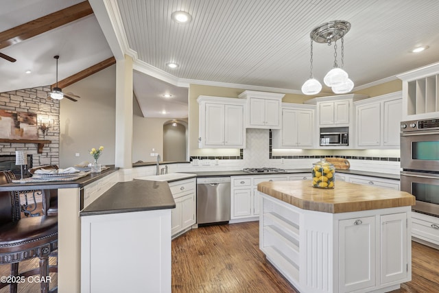 kitchen featuring a sink, wood counters, backsplash, dark wood-style floors, and stainless steel appliances