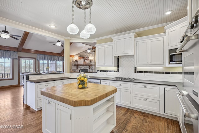 kitchen with wood counters, stainless steel gas stovetop, a ceiling fan, and white cabinetry