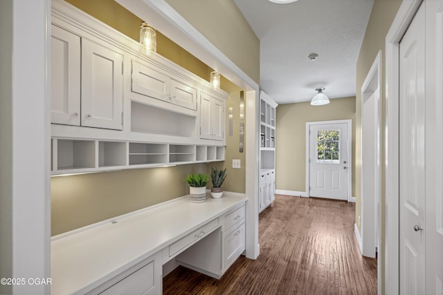 hall featuring baseboards and dark wood-style flooring