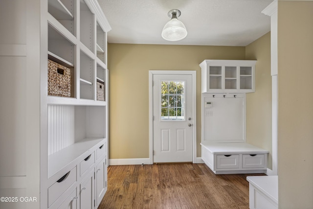 mudroom featuring dark wood-type flooring and baseboards