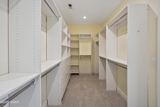 spacious closet with light colored carpet and visible vents