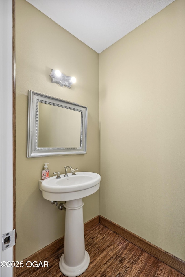 bathroom with baseboards and wood finished floors