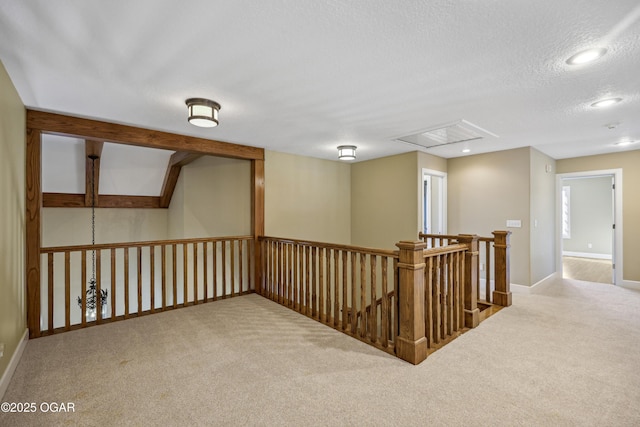 hall featuring carpet floors, attic access, recessed lighting, a textured ceiling, and an upstairs landing