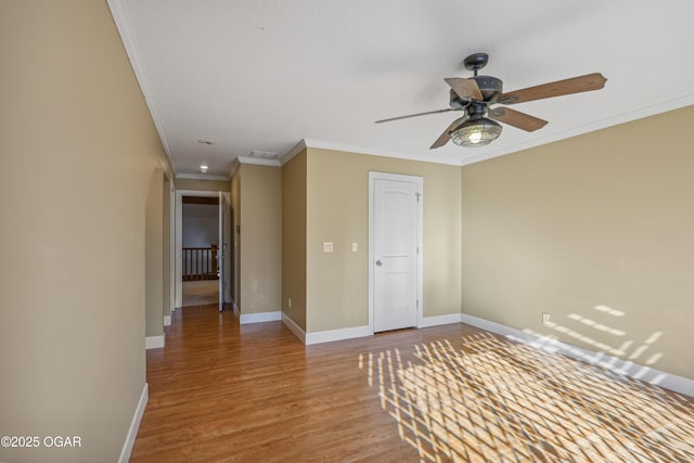 unfurnished bedroom with wood finished floors, baseboards, visible vents, ceiling fan, and crown molding