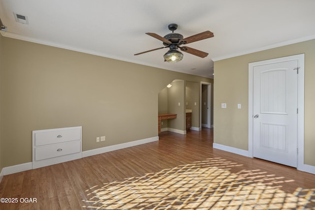 unfurnished bedroom featuring visible vents, crown molding, wood finished floors, and baseboards