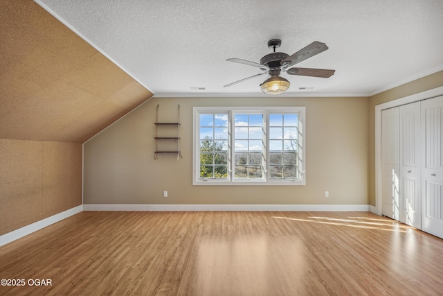 additional living space featuring ceiling fan, baseboards, and wood finished floors