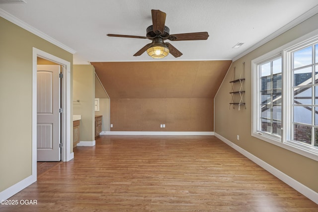 additional living space featuring visible vents, baseboards, ceiling fan, vaulted ceiling, and light wood-style flooring