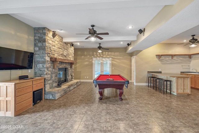 game room featuring baseboards, a fireplace, and a ceiling fan