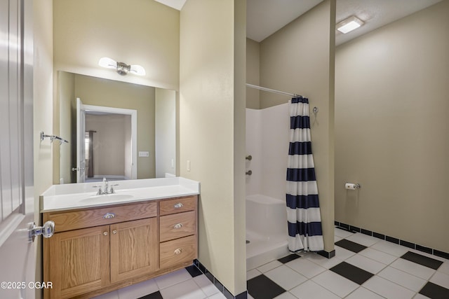 full bath featuring vanity, a shower stall, baseboards, and tile patterned floors