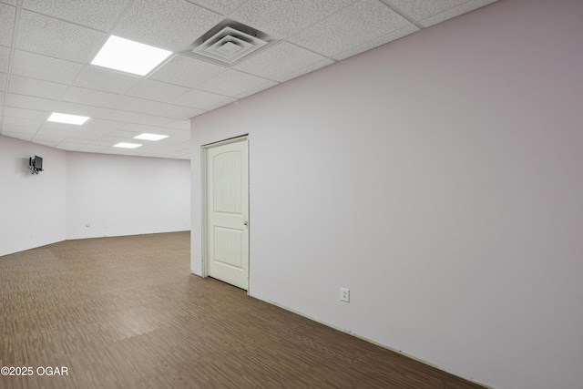 spare room featuring a drop ceiling, visible vents, and wood finished floors