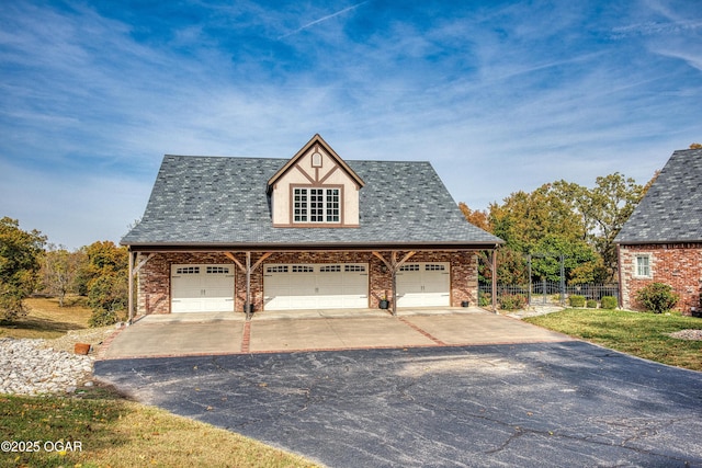 view of front of home with a detached garage, fence, brick siding, and roof with shingles