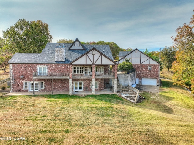 back of property featuring brick siding, stairs, a lawn, french doors, and an attached garage