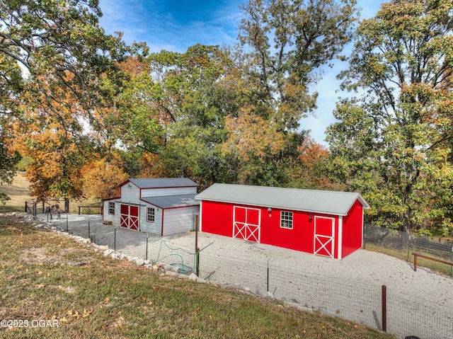 view of barn with a yard and fence