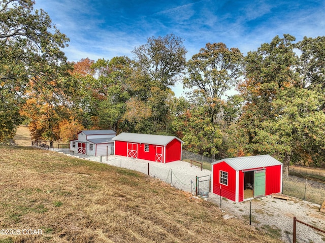 view of yard featuring an outdoor structure, fence, and an outbuilding