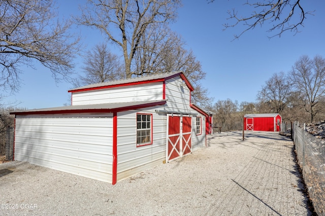 view of outbuilding featuring an outdoor structure and fence