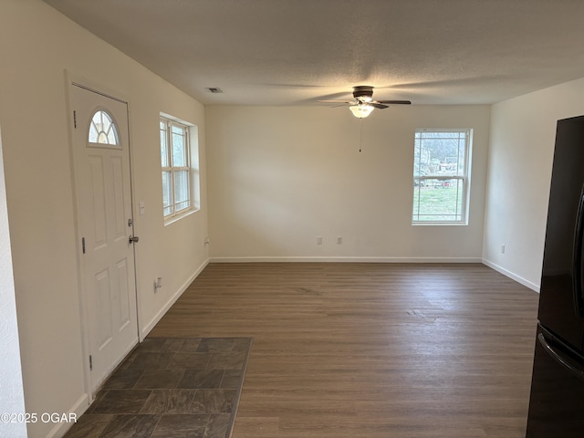 entryway with dark wood-style floors, visible vents, baseboards, ceiling fan, and a textured ceiling