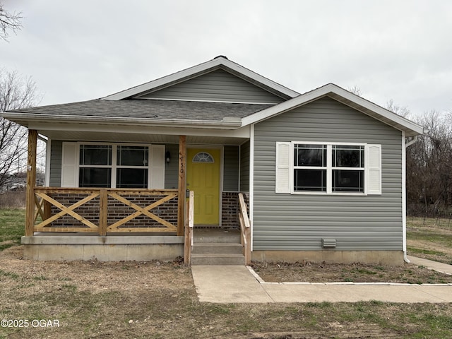 bungalow with a porch and a shingled roof