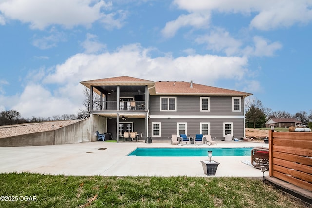 back of house with a patio area, a fenced in pool, a balcony, and fence
