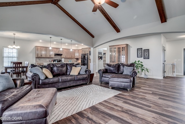 living area with beamed ceiling, high vaulted ceiling, ceiling fan with notable chandelier, dark wood-style floors, and baseboards