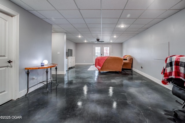 bedroom featuring french doors, baseboards, concrete flooring, and a paneled ceiling