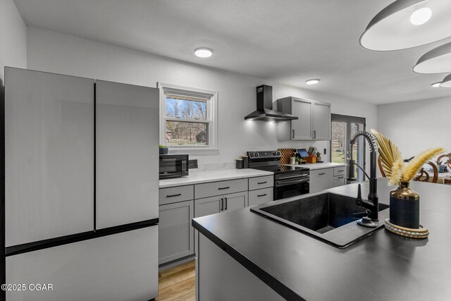 9426 Business 60, Monett, MO 65708 - kitchen with wall chimney range hood, a sink, stainless steel appliances, and gray cabinetry