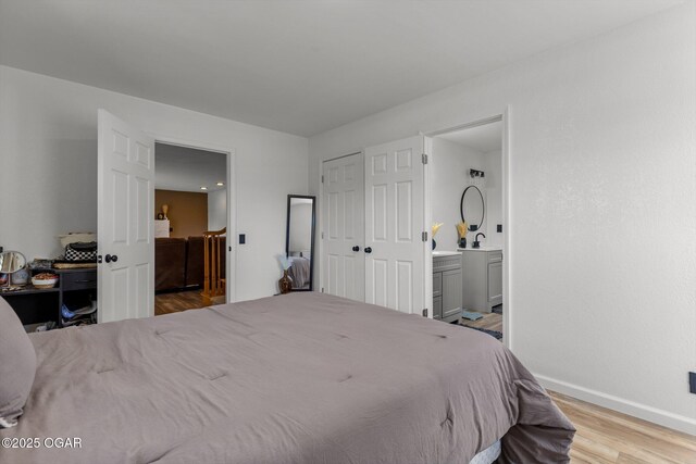 9426 Business 60, Monett, MO 65708 - bedroom with connected bathroom, baseboards, wood finished floors, and a sink