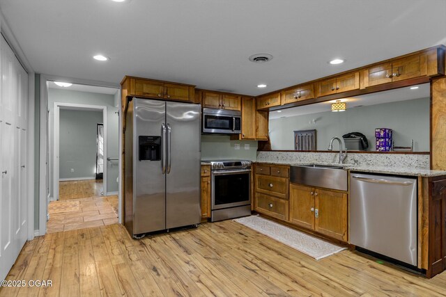 9426 Business 60, Monett, MO 65708 - kitchen with visible vents, light wood finished floors, brown cabinets, stainless steel appliances, and a sink