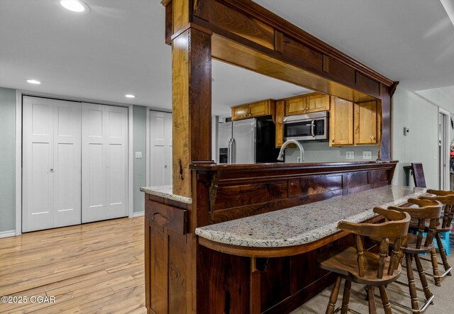9426 Business 60, Monett, MO 65708 - kitchen with light stone countertops, recessed lighting, appliances with stainless steel finishes, a sink, and light wood-type flooring