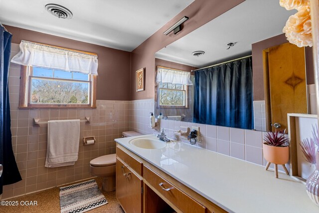 9426 Business 60, Monett, MO 65708 - full bathroom featuring a wainscoted wall, toilet, tile walls, and visible vents